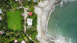 Vista aérea de una zona costera con playa, carretera y una pequeña masa de agua.