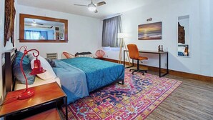 A hotel room with a bed, desk, chair, and a large window. - Eccentric Escape-hop, skip, jump to Plaza District (Oklahoma City)
