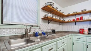 A kitchen with two sinks, wooden shelves above, and a patterned backsplash. - Eccentric Escape-hop, skip, jump to Plaza District (Oklahoma City)