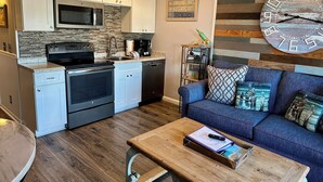 A modern kitchen with white cabinets, stainless steel appliances, and a hutch with a coffee maker. - Seabatical-Beautiful ocean view! w/new bikes & Chairs (Hilton Head Island)