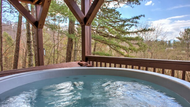 A hot tub with a wooden deck and a view of trees. - Pet-Friendly Log Cabin with Hot Tub & Biltmore Pass | 35 Min to Asheville (Waynesville)