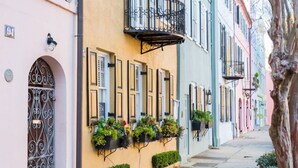 Una hilera de edificios coloridos con balcones y macetas con flores.