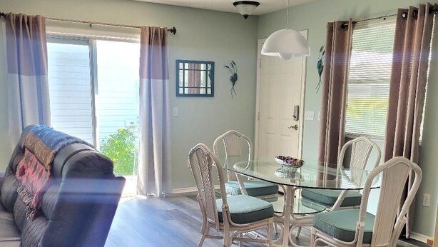 Un salon comprenant un canapé, une table à manger avec des chaises et un ventilateur de plafond.