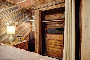 A wooden room with a bed, a dresser, and a guitar. - River Bungalow on the Colorado River 2 Miles From Historic Bastrop, Texas (Bastrop)