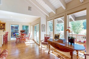 Cozy dining area with a wooden table and comfortable seating, offering a view of the outdoors.
