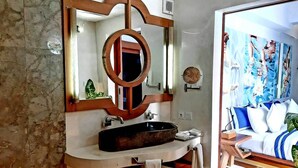 Een badkamer met een grote spiegel, een wastafel en een handdoekrek.