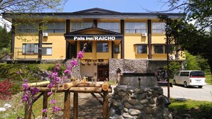 Un edificio amarillo con un cartel que dice "Pals Inn RAICHO".