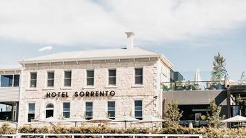 A two-story building with a stone facade and a sign reading 'HOTEL SORRENTO'.