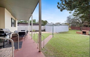 A covered patio area with a grill and seating, a fenced yard, and a shed. - Cozy, Pet Friendly, Family Friendly, Boat Friendly (Rosebud)