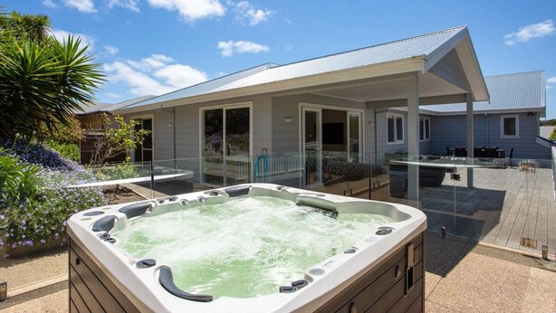 A hot tub in a backyard with a house in the background. - Lady Nelson, Sorrento - hot tub. (SORRENTO)