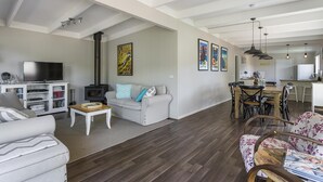 A spacious living area with a fireplace, sofa, and dining table.