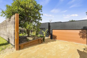 A modern house with a garage, a tree, and a well-maintained garden.