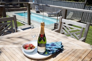 Eine Holzterrasse mit einer Flasche Moët & Chandon Champagner, einem Glas und einer Schale Erdbeeren.