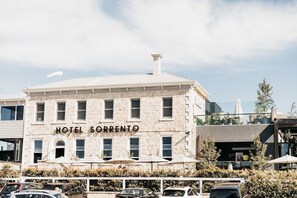 A building with a sign reading 'HOTEL SORRENTO' and a parking lot in front. - Sorrento Beach House. (SORRENTO)