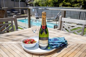 A bottle of Moët & Chandon champagne on a table with a bowl of strawberries and a glass. - Sorrento Beach House. (SORRENTO)