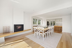Een modern interieur met een open haard, eethoek en keuken.