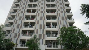 A multi-story residential building with a modern design, featuring balconies on each floor. - Grand Seven Place (Pak Kret)