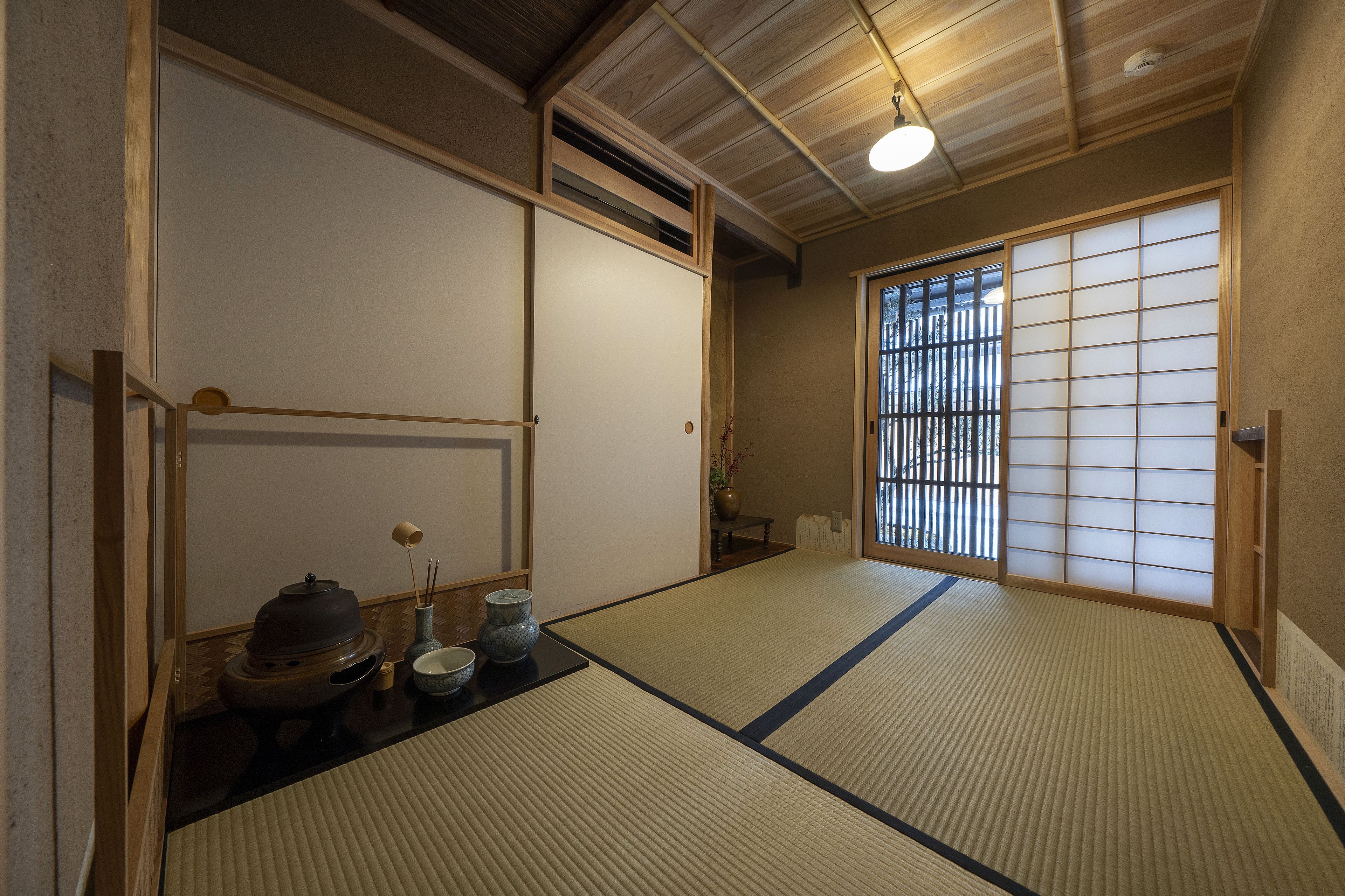 A traditional Japanese room with tatami flooring, sliding doors, and a shoji screen.
