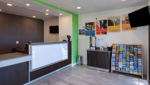 A reception area with a counter, a coffee machine, and a magazine rack. - Studio 6 Barstow, CA (Barstow)