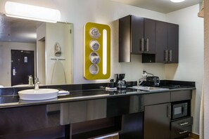 A modern bathroom with a sink, mirror, and a towel rack. - Studio 6 Fairfield, CA - Napa Valley (Fairfield)