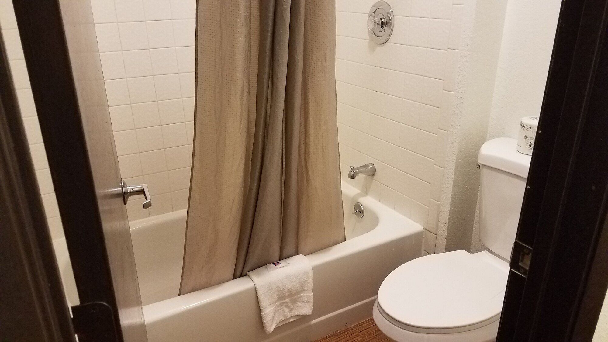 Un baño con bañera, inodoro y cortina de ducha.