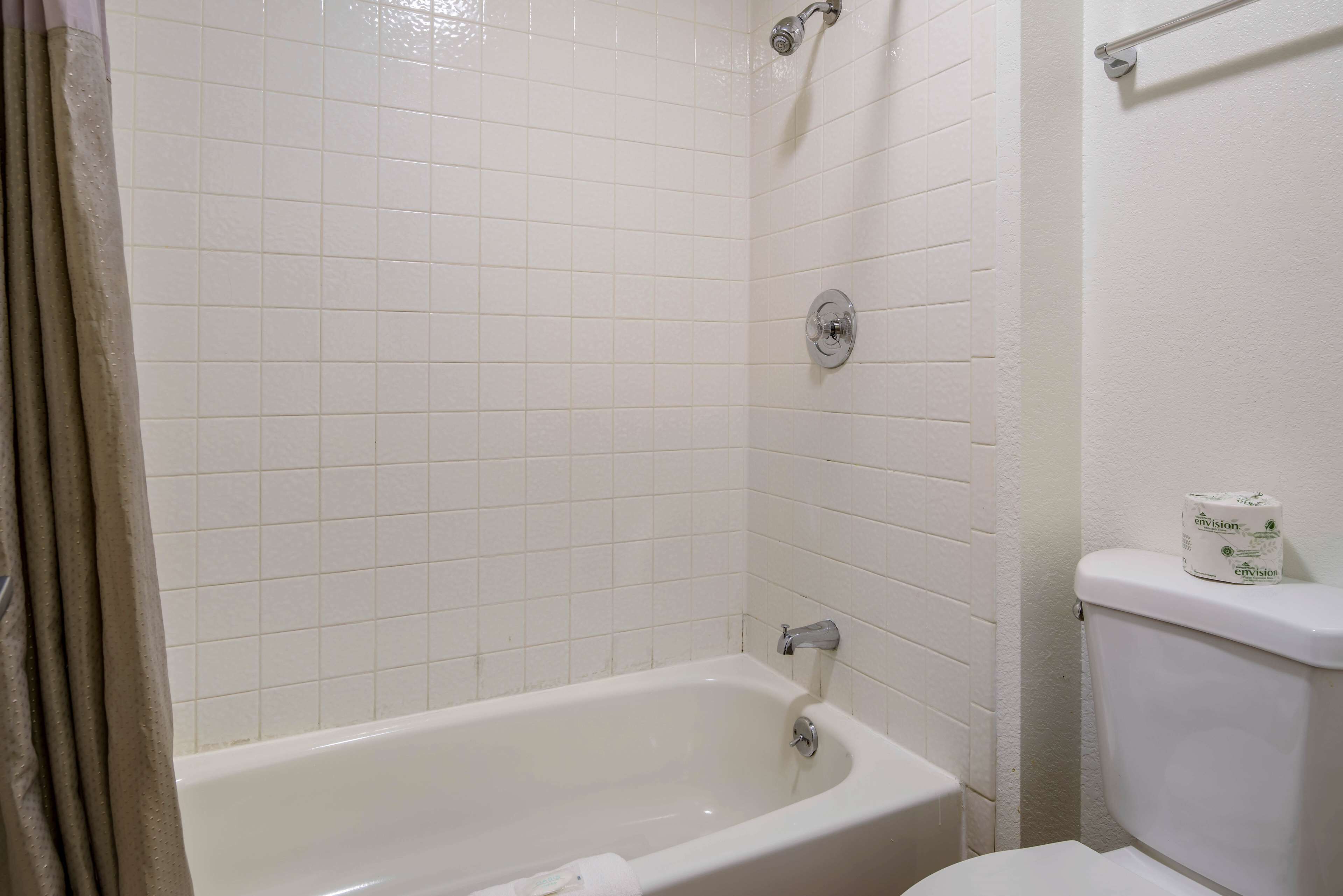 A bathroom with a bathtub, toilet, and a towel rack.
