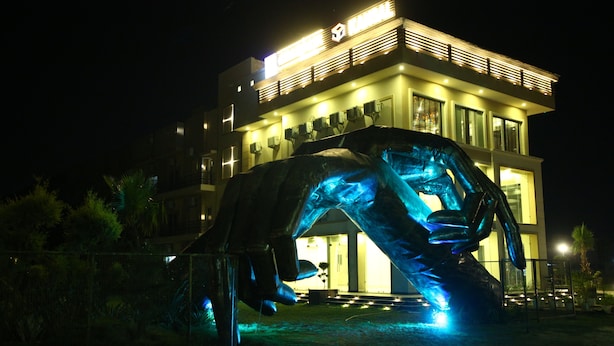 A modern building with a large sculpture in front. - Anandam Clarks Inn Suites Vrindavan (Mathura)