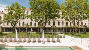 Área de piscina com espreguiçadeiras e piscina.
