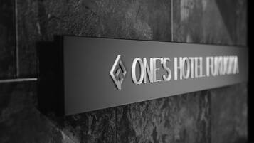 A sign for "ONE'S HOTEL FRONDA" mounted on a textured wall.