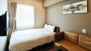 Ein Hotelzimmer mit Bett, Sofa, Fernseher und einem Gemälde an der Wand.