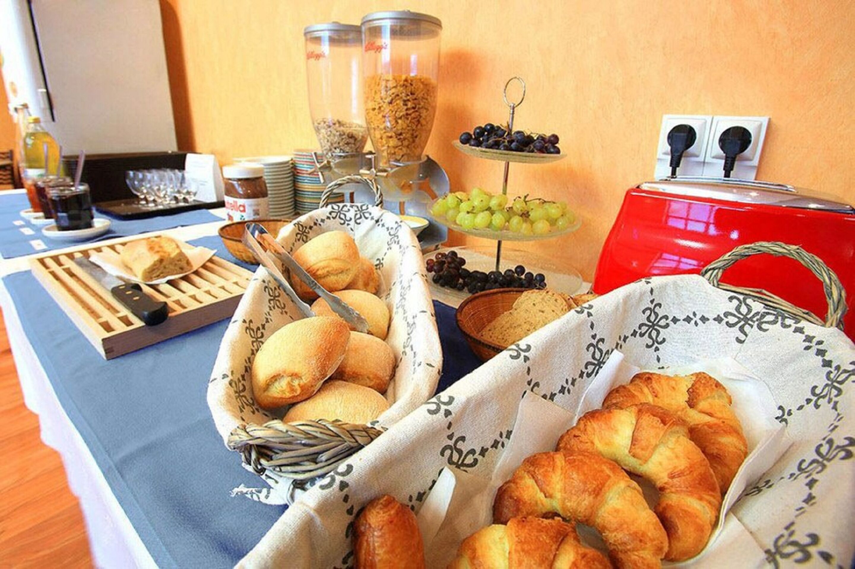Buffet de café da manhã com pães, doces e frutas.