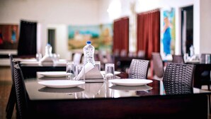 A dining area with tables set for service, including water bottles and napkins. - Kananam Retreat (Thodupuzha)