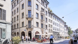 A historic building with multiple floors, large windows, and a balcony. - Consum Boutique Hotel (Basel)