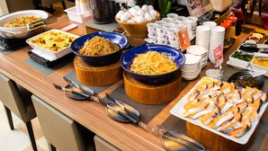 A buffet table with various dishes, including a large bowl of noodles, a bowl of eggs, and a tray of fish. - Natural Hot Spring SUPER HOTEL Kumamoto Chamber of Commerce (Kumamoto)