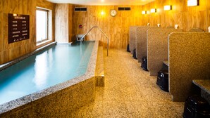 A swimming pool with a wooden interior, a clock on the wall, and a sign with text. - Natural Hot Spring SUPER HOTEL Kumamoto Chamber of Commerce (Kumamoto)