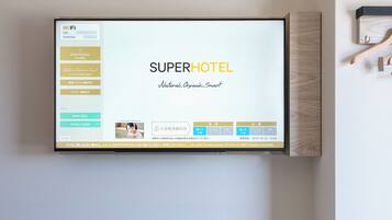 Habitación de hotel con una pantalla grande mostrando el nombre y los servicios del hotel.