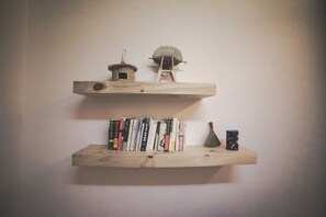 Two wooden shelves with books and decorative items. - Wansangol Guesthouse (Jeonju)