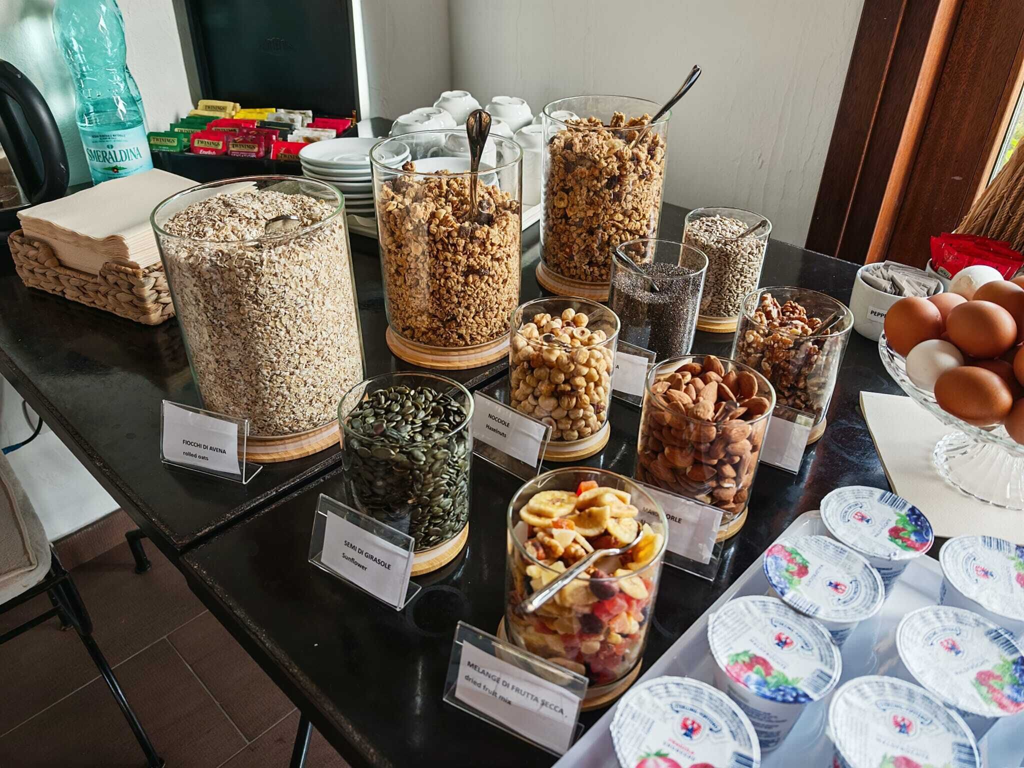Un buffet con diversi cibi e contenitori etichettati con indicazione del loro contenuto.
