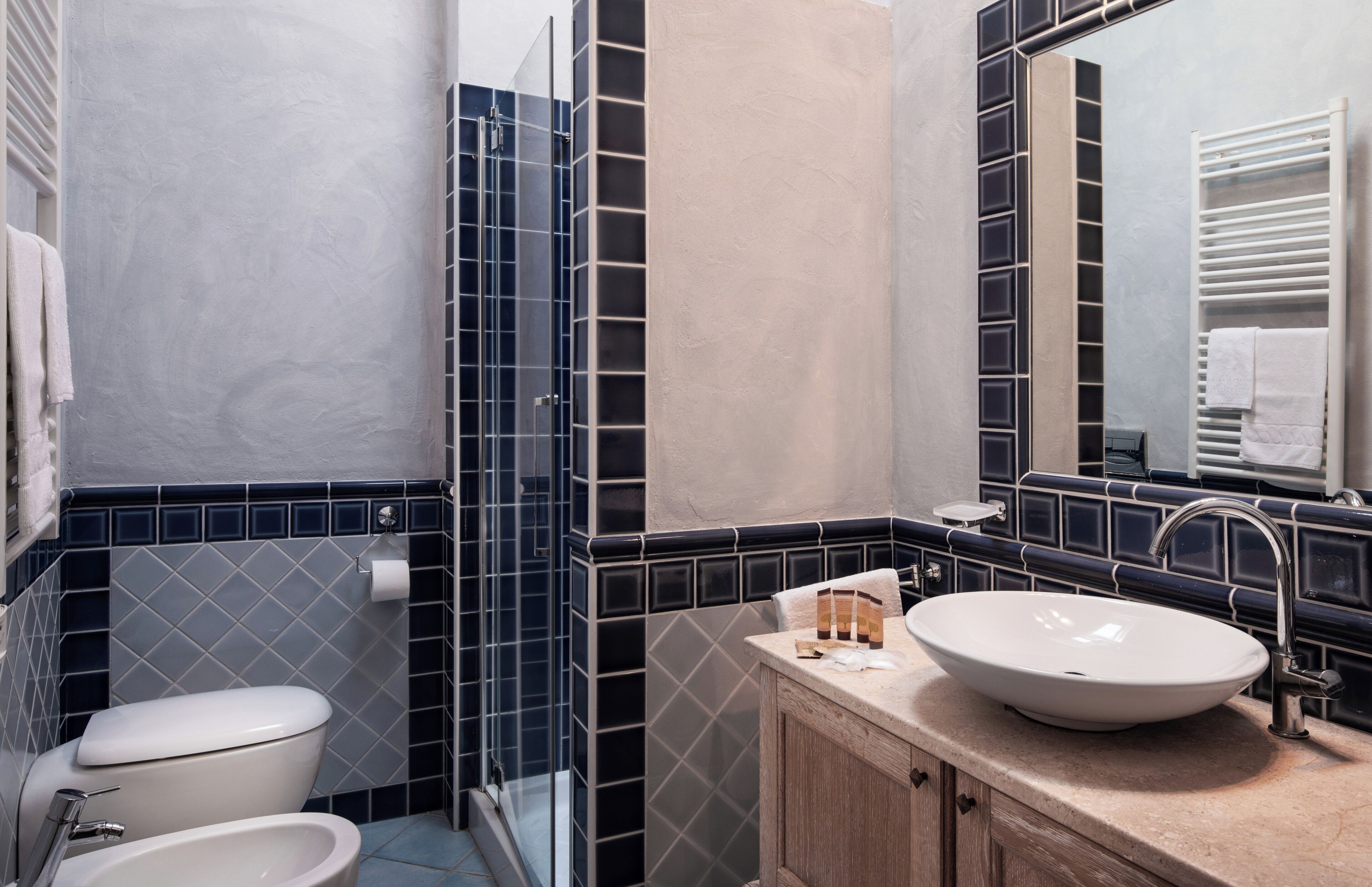 A bathroom with a toilet, bidet, and sink with a mirror above.