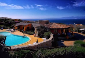 Een seizoensgebonden buitenzwembad en ligstoelen