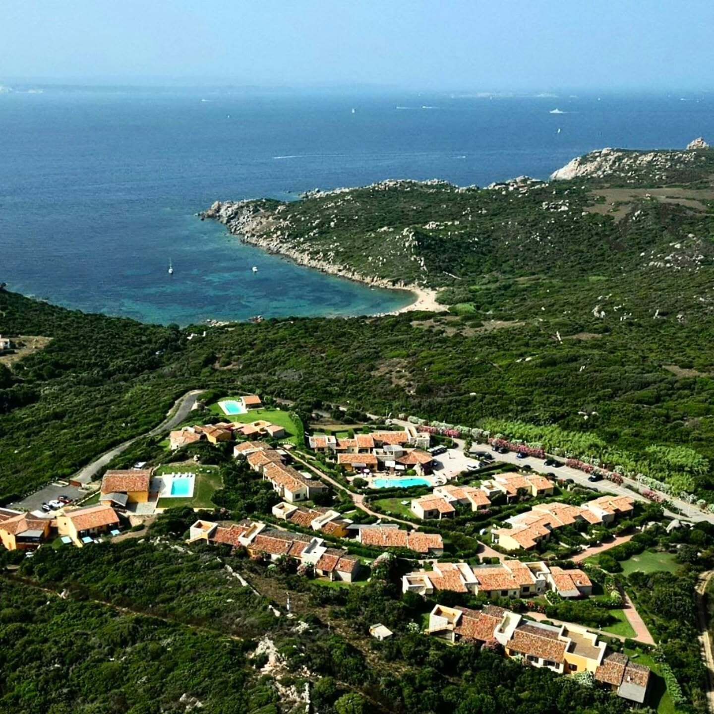 Um resort à beira-mar com villas, piscina e vista para o mar.