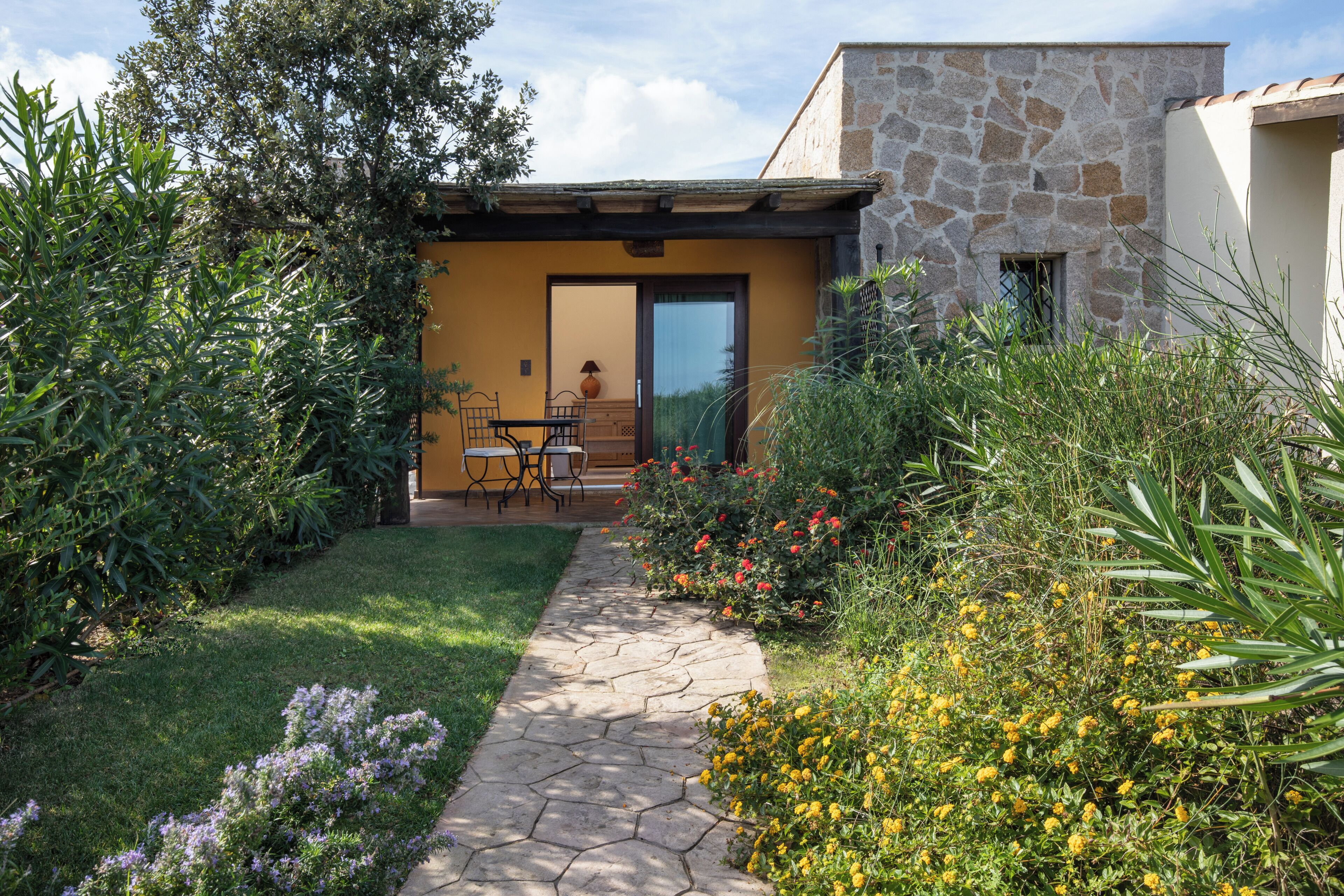 Un edificio in pietra con un patio, un tavolo e sedie.