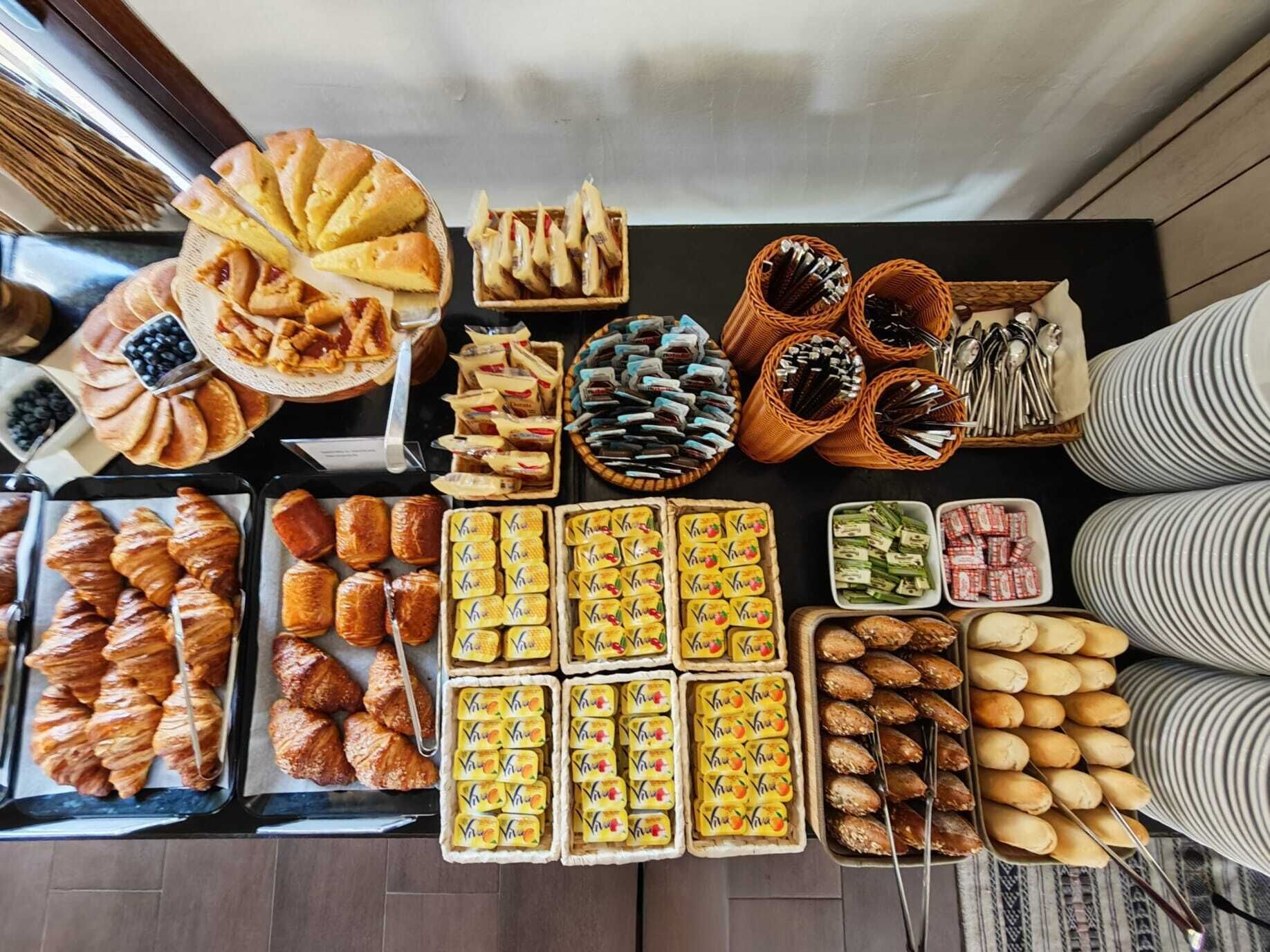 A variety of baked goods and pastries displayed on trays and in baskets, suggesting a bakery or cafe setting.