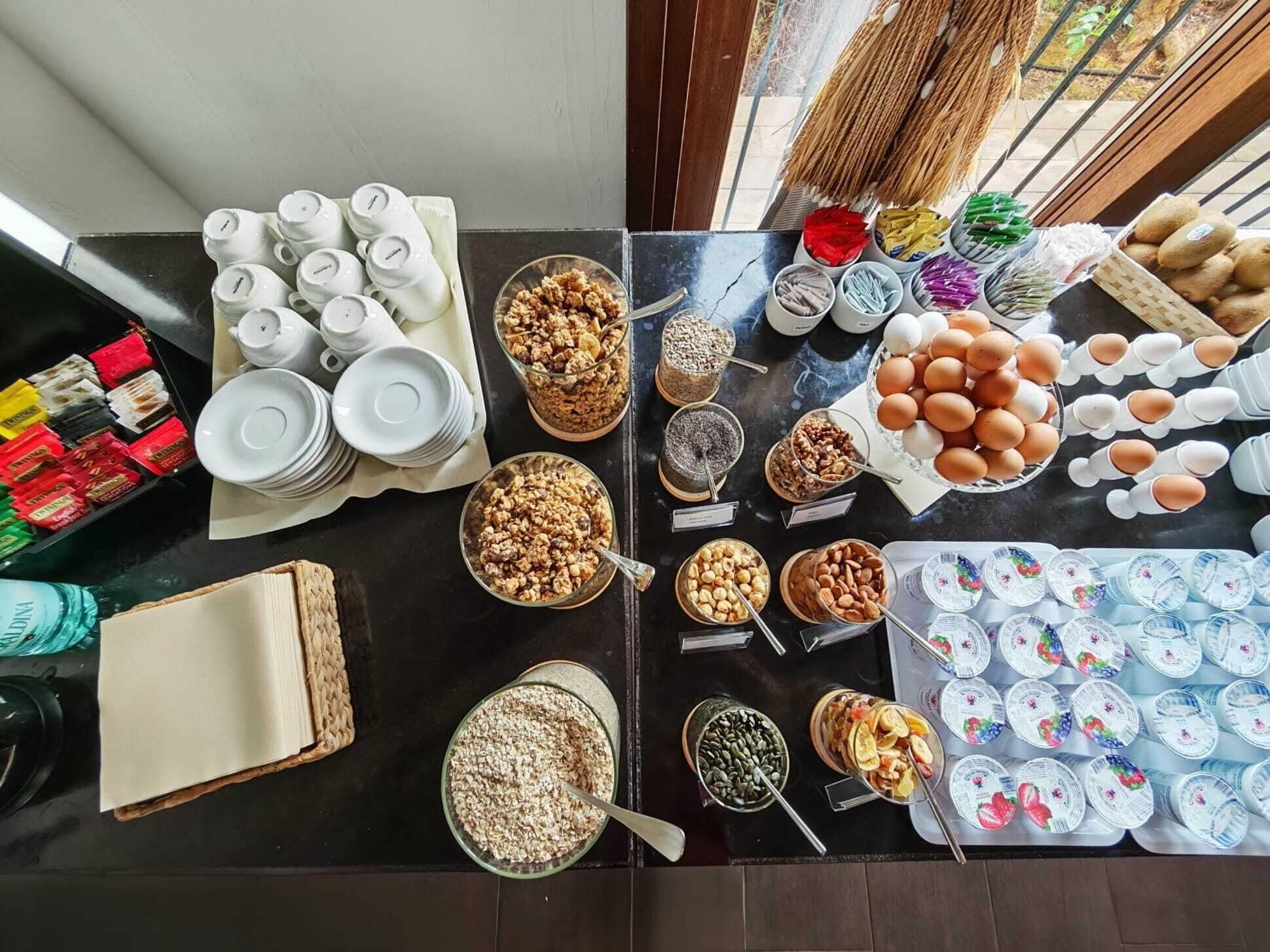 A buffet table with various food items and utensils.