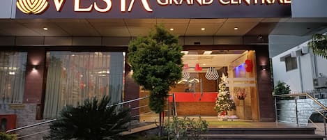 The exterior of Vesta Grand Central hotel with a prominent entrance, steps leading up to the lobby, and a Christmas tree decoration.
