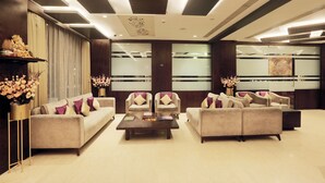A modern lobby with sofas, armchairs, and a coffee table. -  Vesta Grand Central Udaipur (Udaipur)