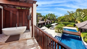 A balcony with a hot tub, a swimming pool, and a view of a tropical resort area. - Villa Alila (Holetown)