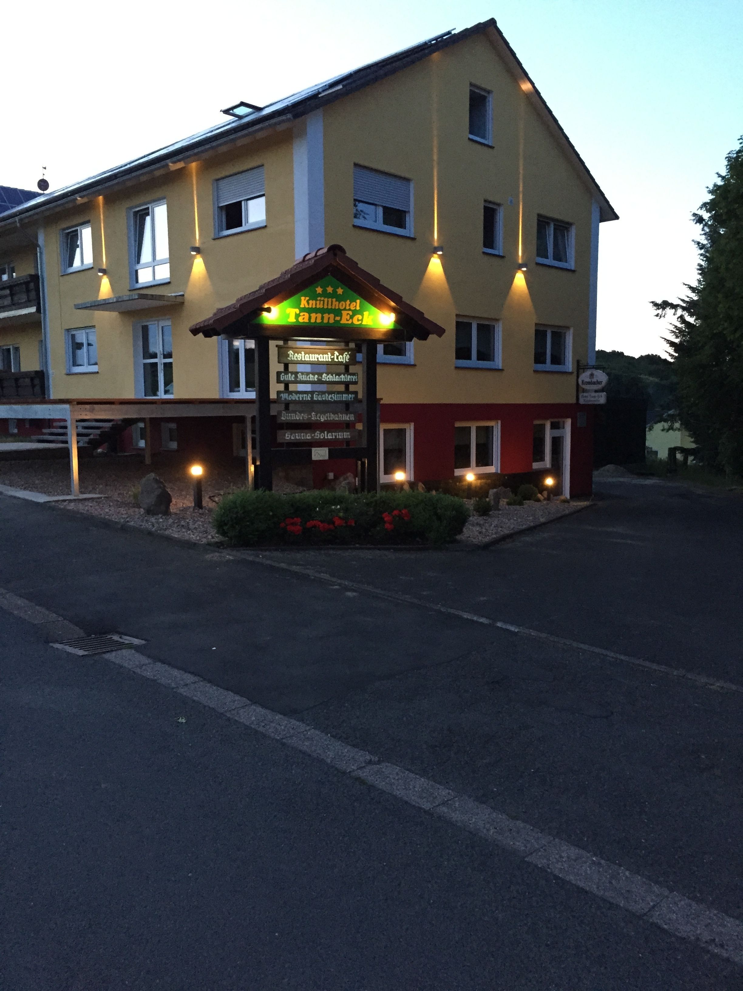 A hotel with a sign indicating it is a restaurant and café, featuring amenities like a sauna, modern guest rooms, and a garden.