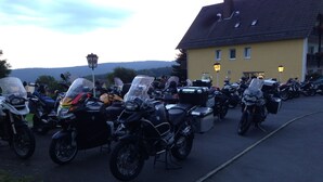 A row of parked motorcycles in front of a yellow building with a sloped roof. - Knüllhotel Tann-Eck (Knullwald)