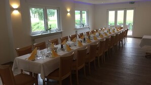A long dining table set with chairs, white tablecloths, and yellow napkins. - Knüllhotel Tann-Eck (Knullwald)